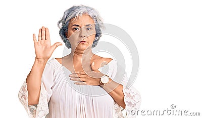 Senior woman with gray hair wearing bohemian style swearing with hand on chest and open palm, making a loyalty promise oath Stock Photo