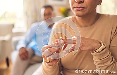 Senior woman, hands and ring in divorce, fight or conflict from disagreement or argument on sofa at home. Elderly couple Stock Photo