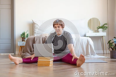 Senior woman having online video call with a coach before pilates workout at home. Stock Photo