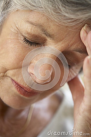 Senior Woman With Head In Hands Looking Weary Stock Photo