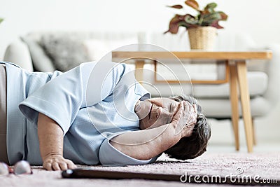 Senior woman with a headache after falling down at home Stock Photo