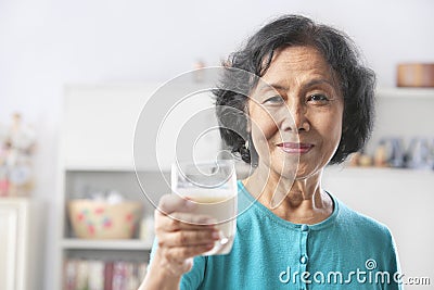 Senior woman holding glass of milk Stock Photo