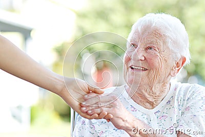 Senior Woman Holding Hands with Caretaker Stock Photo