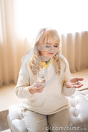 Senior woman holding pills and a glass of water Stock Photo