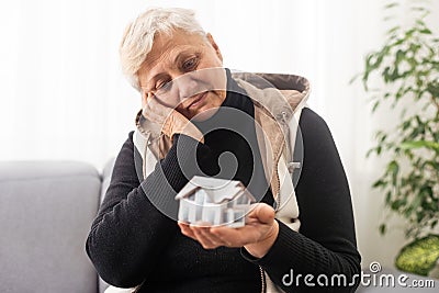 Senior woman with house figure. Home care concept Stock Photo