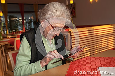 Senior woman looking at screen of tablet computer Stock Photo