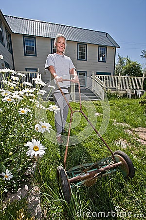 Senior woman mowing lawn Stock Photo