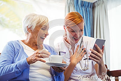 Senior woman and nurse using digital tablet Stock Photo