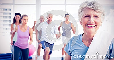 Senior woman with people exercising in fitness studio Stock Photo