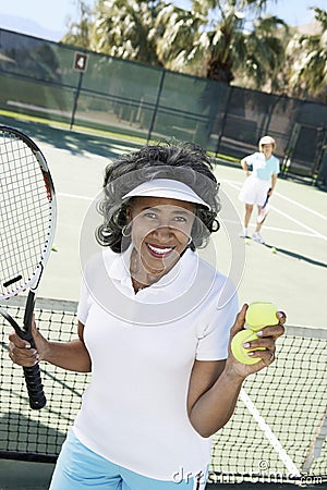 Senior Woman Playing Tennis In Court Stock Photo