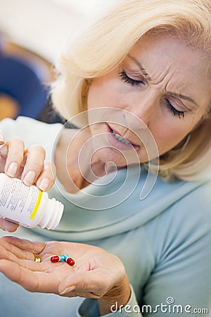 Senior Woman Pouring Pills Out Of Bottle Stock Photo
