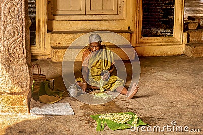 A senior woman preparing jasmine flowers to sell in a Hindu temple in India. Editorial Stock Photo