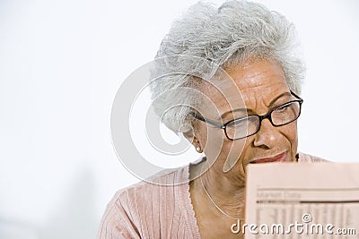 Senior Woman Reading Stocks And Shares In Newspaper Stock Photo