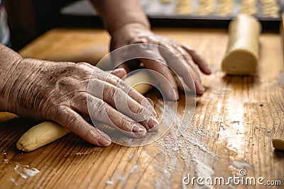 Senior woman is rolling pastry dough by hand. Stock Photo