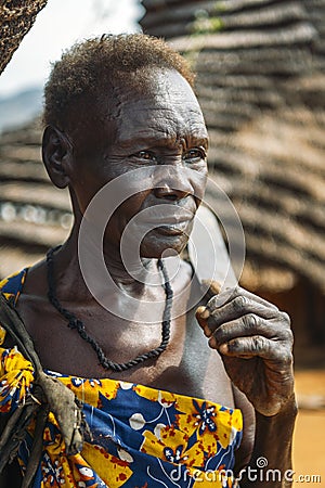 BOYA TRIBE, SOUTH SUDAN - MARCH 10, 2020: Senior woman with short hair carrying knife on shoulder and looking away on blurred Editorial Stock Photo
