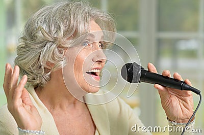 Senior woman singing with microphone Stock Photo