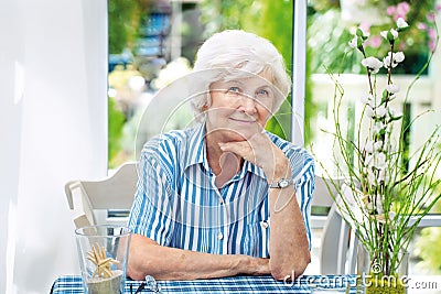 Senior woman sitting at home Stock Photo