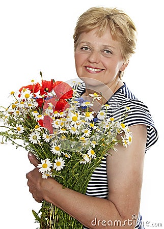 Senior woman smiling with bunch of wild flowers Stock Photo