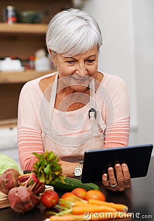 Senior woman, tablet and vegetables for cooking wholesome, healthy and nutritional food at home. Retired lady Stock Photo