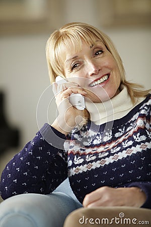 Senior woman talking on cordless phone at home Stock Photo