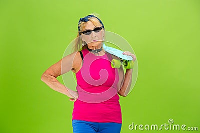 Senior woman in ultra trendy attire isolated on bright green background Stock Photo
