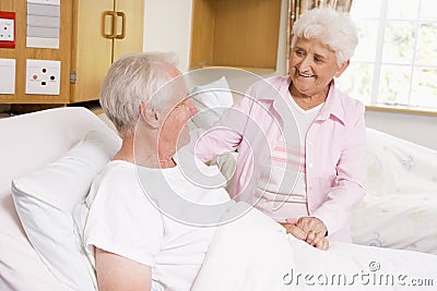 Senior Woman Visiting Her Husband In Hospital Stock Photo