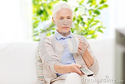 Senior woman watching tv and drinking tea at home Stock Photo