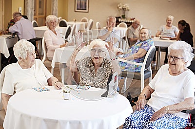 Senior Woman Winning Game Of Bingo In Retirement Home Stock Photo