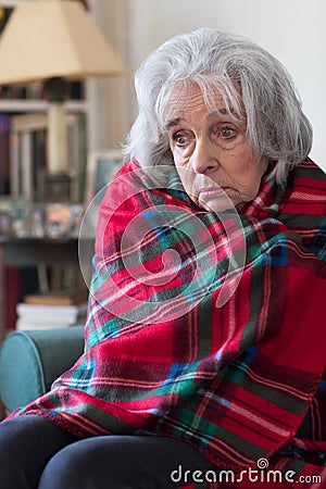 Senior Woman Wrapped In Blanket Unable To Afford Heating Bills Stock Photo