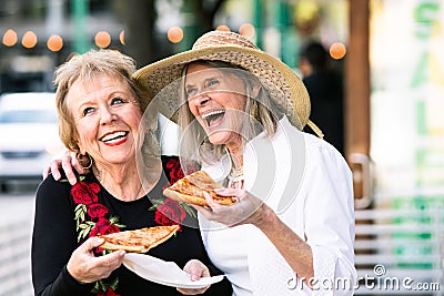 Senior Women Eating Street Food and Laughing Stock Photo