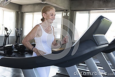 Senior women exercise jogging at gym fitness smiling and happy. elderly healthy lifestyle Stock Photo