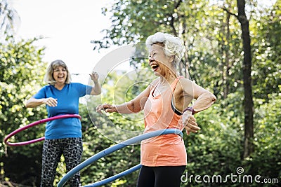 Senior woman exercising with a hula hoop Stock Photo