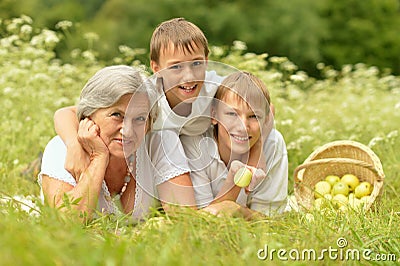 Woman with two boys lying on grass Stock Photo