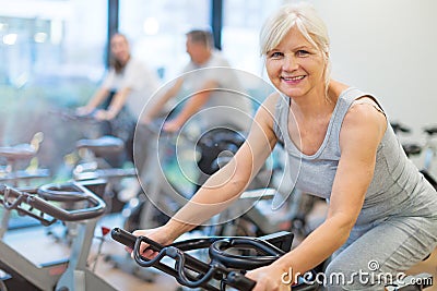Seniors on exercise bikes in spinning class at gym Stock Photo