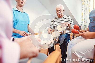 Seniors in nursing home making music with rhythm instruments Stock Photo