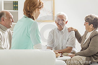 Seniors sitting with nurse Stock Photo