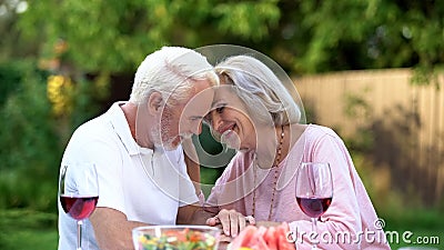 Seniors sitting at table and remembering their life together, happy marriage Stock Photo