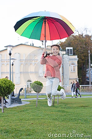 Sense of freedom. Multicolored umbrella for little free happy girl. Little girl free with umbrella. Positive mood in Stock Photo