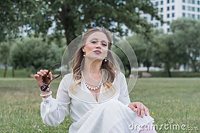 Sensitive portrait of an elegant girl in a park on the lawn Stock Photo