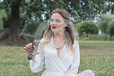Sensitive portrait of an elegant girl in a park on the lawn Stock Photo