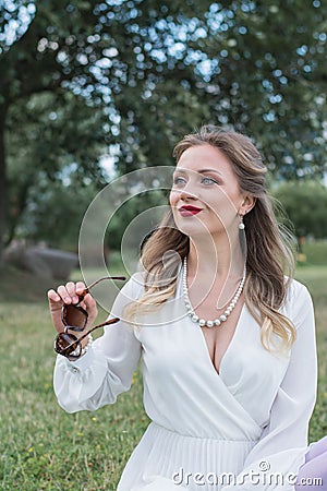 Sensitive portrait of an elegant girl in a park on the lawn Stock Photo