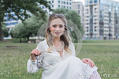 Sensitive portrait of an elegant girl in a park on the lawn Stock Photo