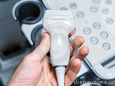 Sensors of ultrasound machine in man`s hand. Modern medical equipment. Detail. Close-up Stock Photo