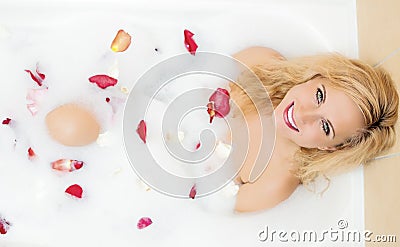 Sensual Alluring Caucasian Blond Female in Foamy Bathtub Filled with Flowery Petals Stock Photo