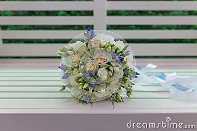 Sensual bright bouquet of fresh flowers with ribbons on the background of a white bench Stock Photo