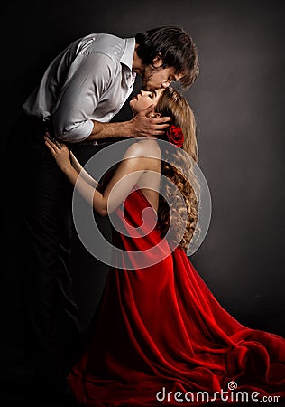 Sensual Couple Kissing in Love. Handsome Man hugging romantic Woman in red Dress. Valentines People Concept Stock Photo