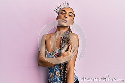 Sensual hispanic transgender woman wearing queen crown and posing glamorous with seductive face wearing sexy lingerie Stock Photo