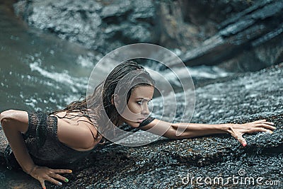 Sensual lady hiking on the wet rocks Stock Photo