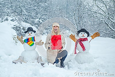 Sensual winter girl posing and having fun. People in snow. Joyful girl Having Fun with snowman in Winter Park. Winter Stock Photo