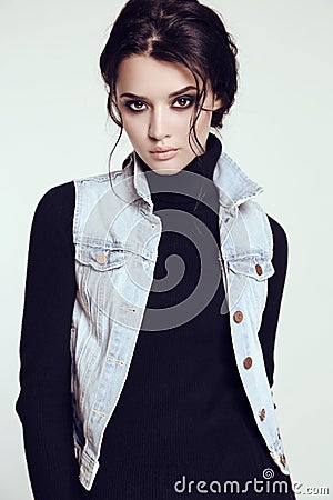 Sensual woman with dark hair and bright makeup, in jeans jacket Stock Photo